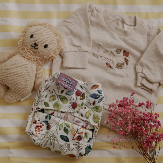 Baby clothing and toy on a striped yellow and white background